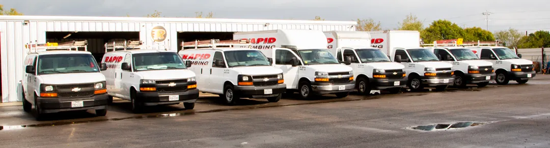 Rapid Plumbing's fleet of branded service vans and trucks lined up at the Schertz shop