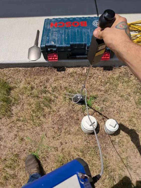 Rapid Plumbing technician using leak-listening equipment over a lawn