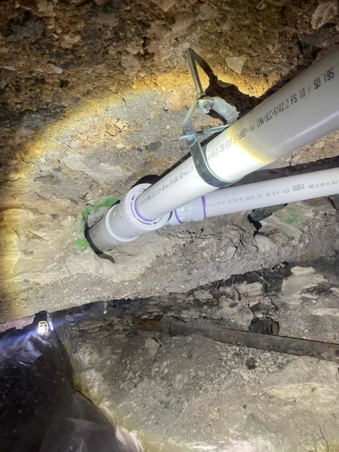 Under-slab tunnel with new PVC drain line hung by Rapid Plumbing